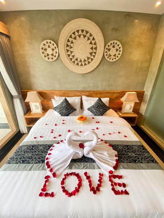 ein Schlafzimmer mit einem Bett mit roten Rosen darauf in der Unterkunft Goutama Homestay in Ubud