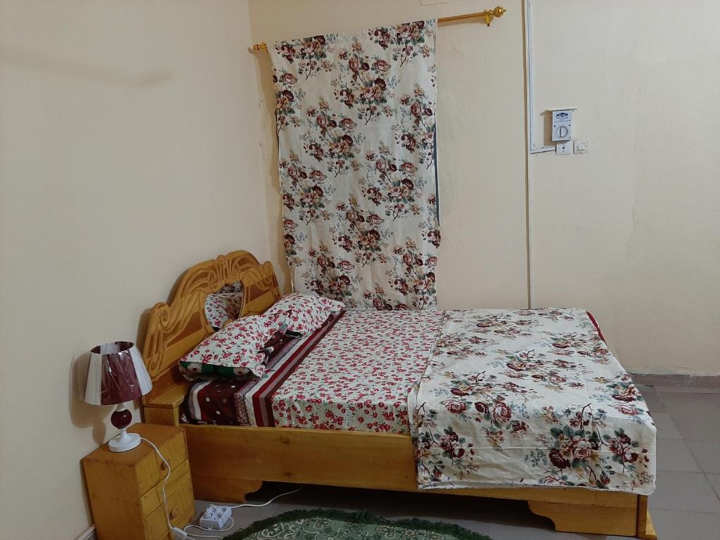 a small bedroom with a bed with a floral bedspread at Appartement chambre salon climatisées, cuisine in Bamako