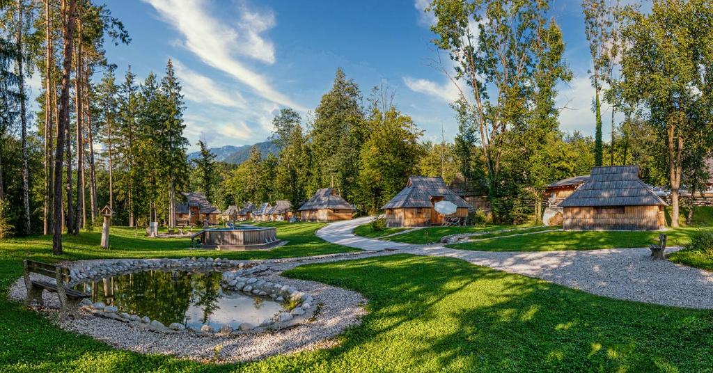 Stahovica的住宿－Slovenia Eco resort，公园里一群小屋,有池塘