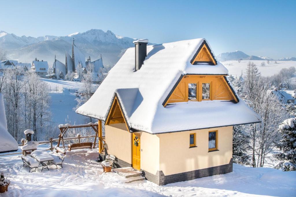 een huis met een dak bedekt met sneeuw bij Tatrzańskie Chaty in Zakopane