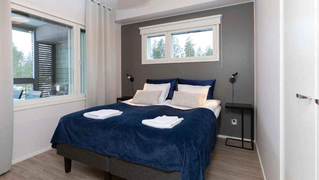 a bedroom with a bed with two towels on it at Holiday Club Saariselkä Superior Apartments in Saariselka