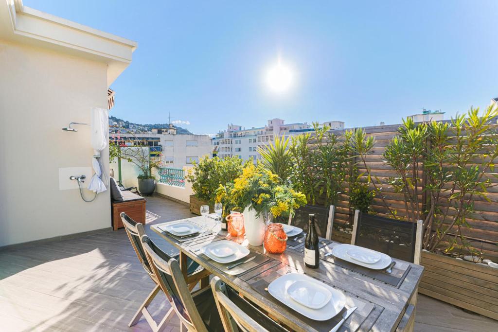 - une table sur un balcon avec vue sur la ville dans l'établissement La Terrasse du Port AP4212, à Nice