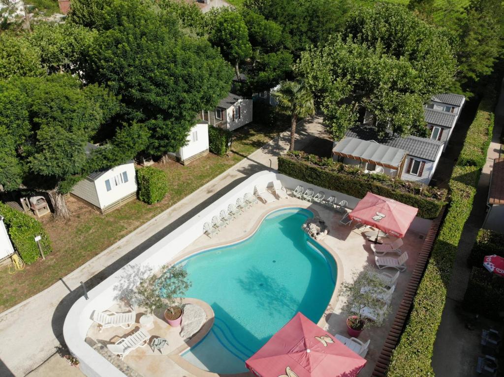 - une vue sur la piscine bordée de parasols dans l'établissement LE CASQUE ROI, à Salavas