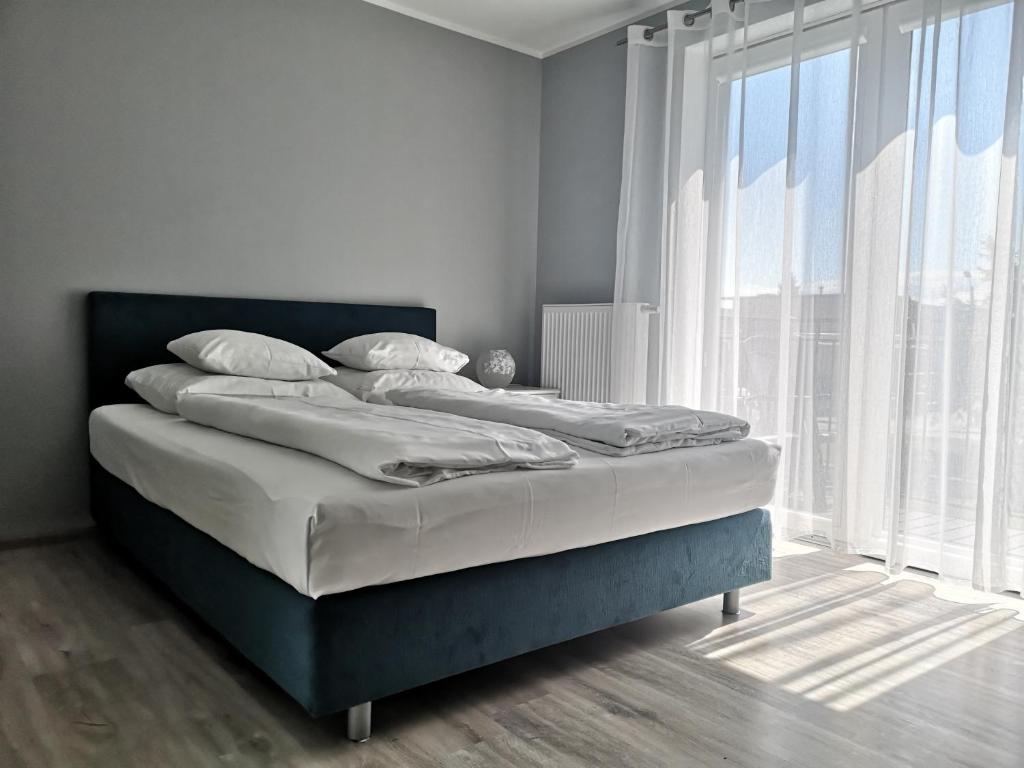 Ce lit se trouve dans un dortoir doté d'une grande fenêtre. dans l'établissement Bryant - Pokoje & Apartamenty, à Władysławowo