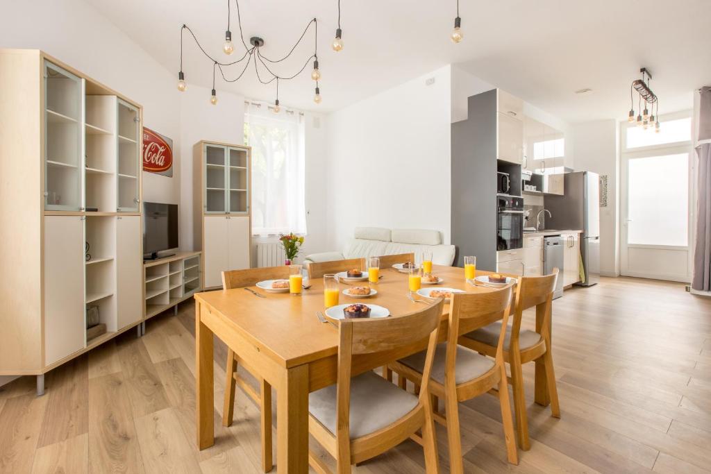 een keuken en eetkamer met een houten tafel en stoelen bij Grand appartement avec 3 salles de bain in Tourcoing