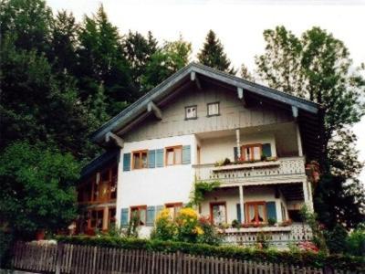 a large house with a fence in front of it at Ferienwohnung Burghartswieser in Ruhpolding