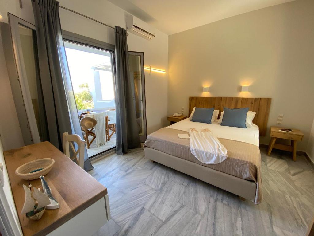 ein Schlafzimmer mit einem Bett und einem großen Fenster in der Unterkunft Kostas & Joanna Studios in Logaras