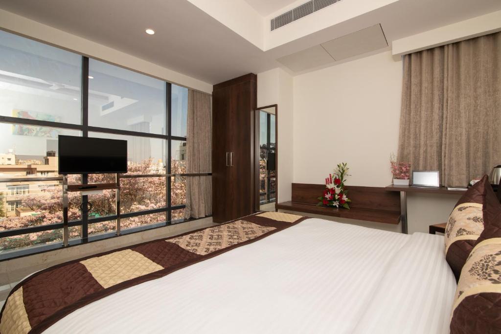 a bedroom with a large bed and a large window at Mojatel By Icon in Bangalore