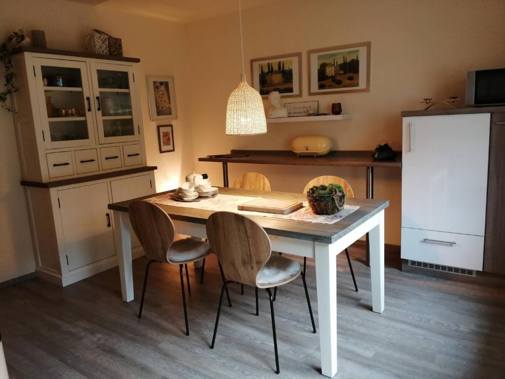 y cocina con mesa, sillas y nevera. en Ferienwohnung Rheinzeit beim Toni, en Boppard