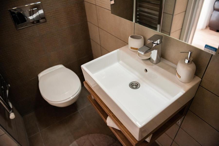 łazienka z białą umywalką i toaletą w obiekcie Apartmani Jovčić w mieście Leskovac