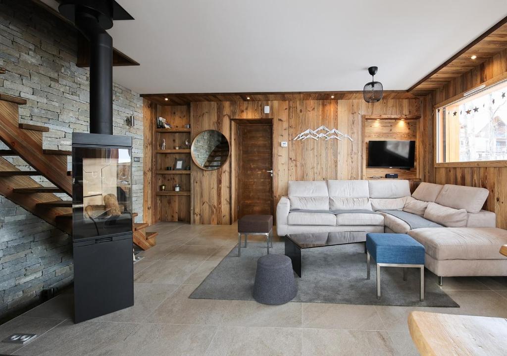 a living room with a couch and a fireplace at Chalets Choseaux Lézami in Saint-Sorlin-dʼArves
