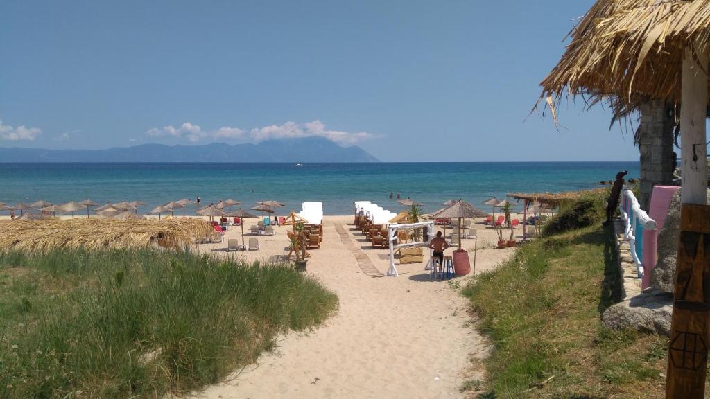a beach with chairs and umbrellas and the ocean at Haus Despina in Sarti