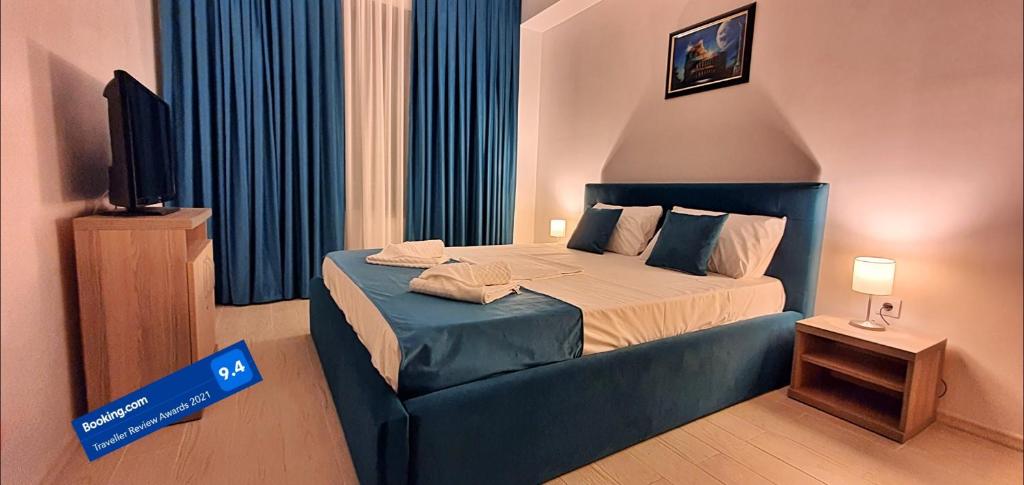 ein Hotelzimmer mit einem Bett und einem TV in der Unterkunft Roma Summerland in Mamaia