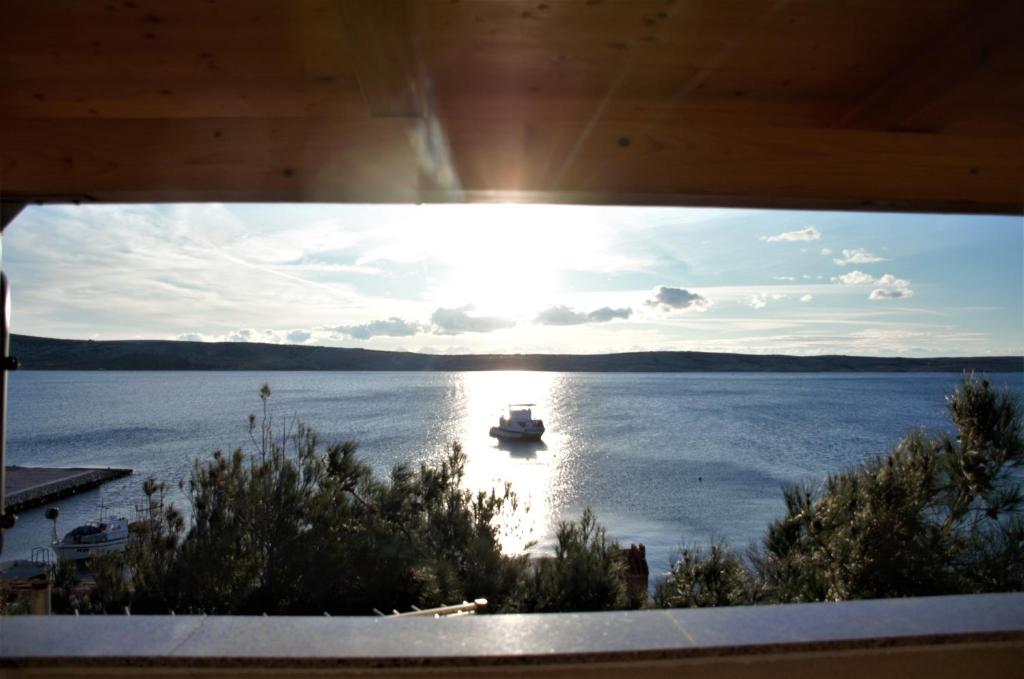 a view of a boat in the water from a window at APARTMANI KRISTIJAN in Kustići