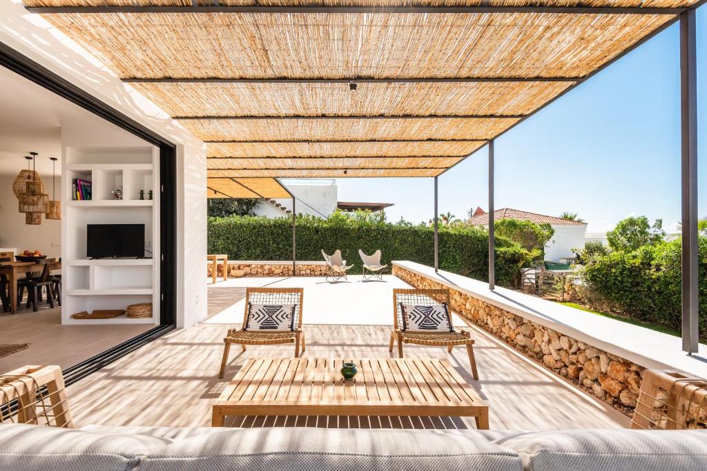 un patio con sofá, mesa y sillas en Villa Baixa - Es Canutells, en Es Canutells