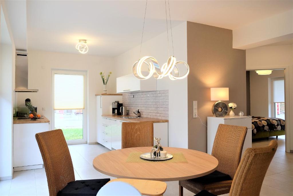 eine Küche und ein Esszimmer mit einem Tisch und Stühlen in der Unterkunft family + friends apartment ferienwohnung in Ransbach-Baumbach