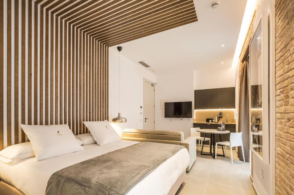 a bedroom with a large bed and a desk at Mon Suites Benlliure in Valencia