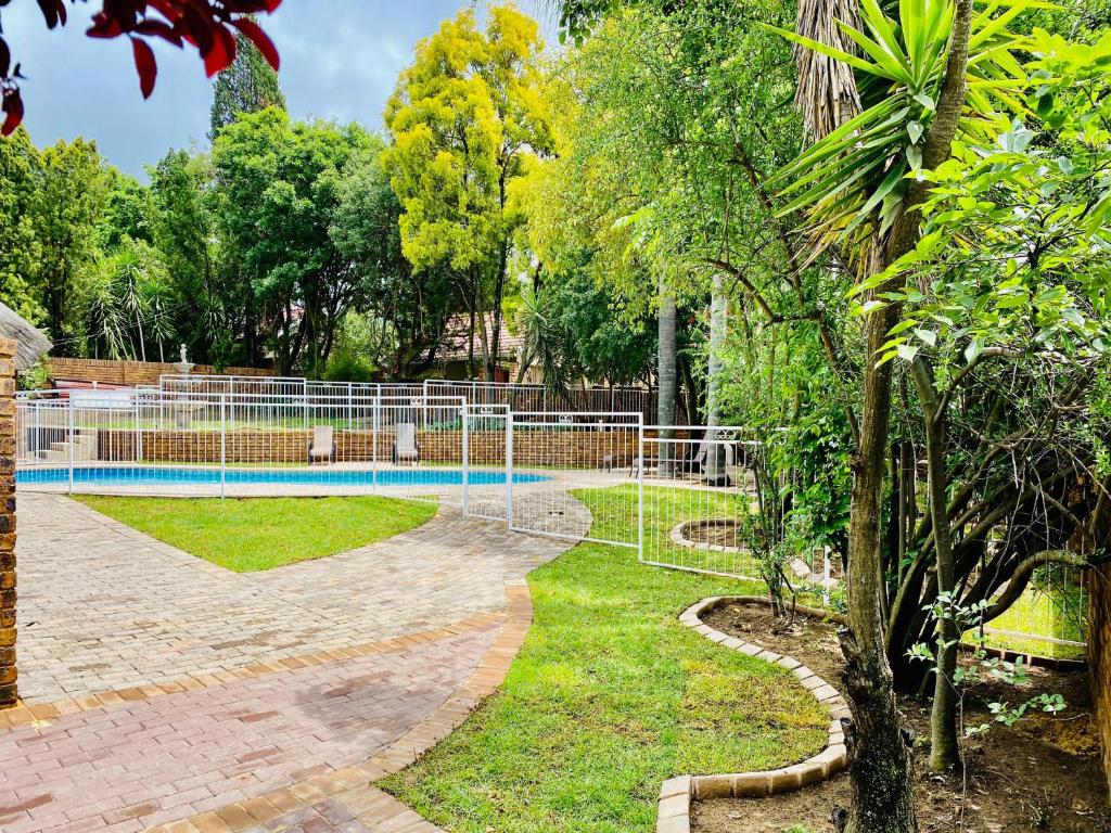 a fence around a swimming pool in a park at C&C HOTEL VIBES Randpark Ridge JHB 14 Units Available in Boskruin
