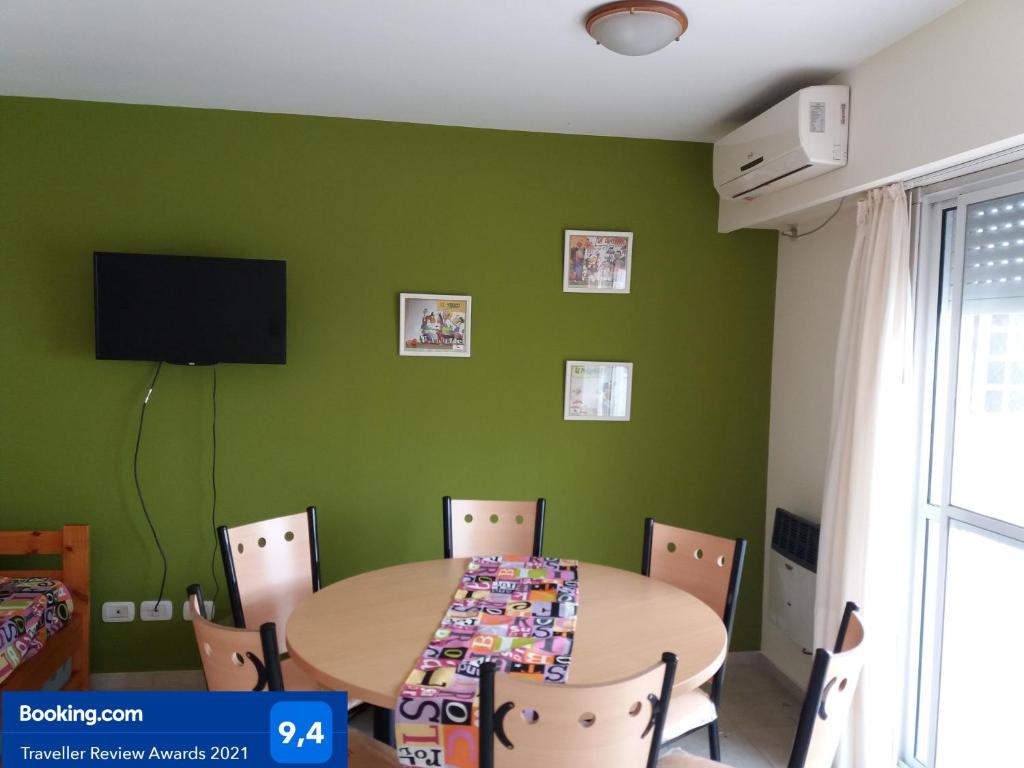 a dining room with green walls and a table and chairs at Como en Casa 2 in Rosario