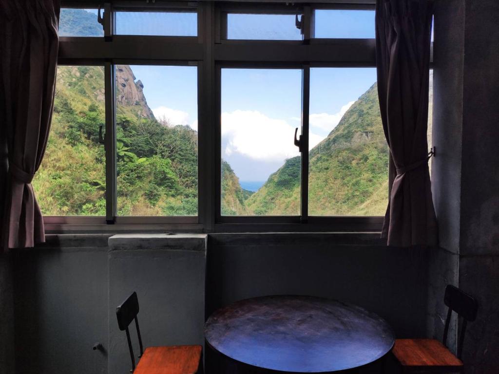 a window with a view of a mountain view at Taipei Jinguashi Cloud Mountain Homestay B&amp;B in Jiufen