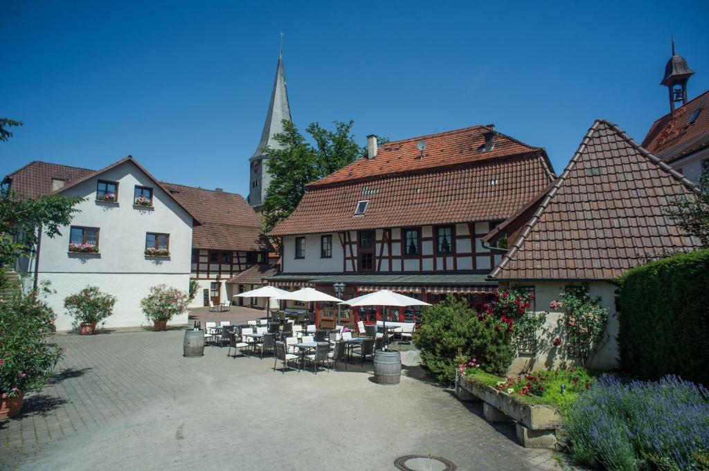 a courtyard with tables and chairs in a building at Landhotel Lutz UG in Oberderdingen