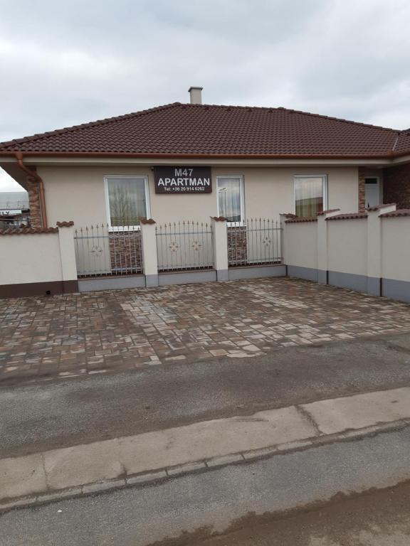 a house with a white fence in front of it at M47 Vendégház-Airport in Debrecen
