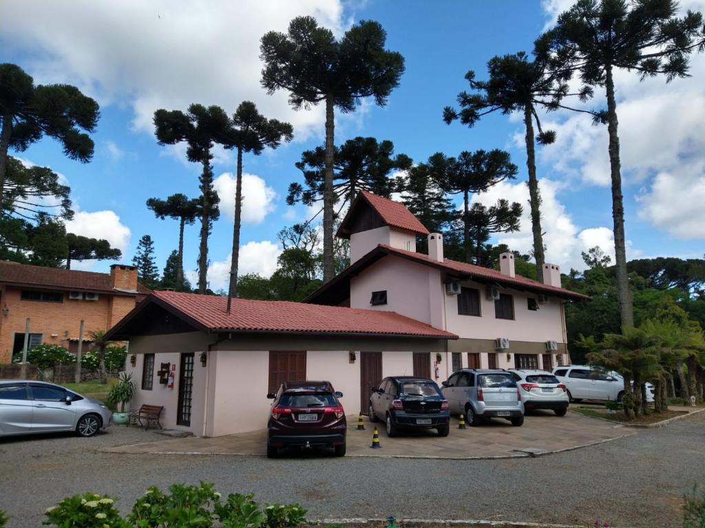 ein Parkplatz vor einem Gebäude mit geparkt in der Unterkunft Jardins de Canela - Aptos e Casas Bairro Nobre em Canela in Canela