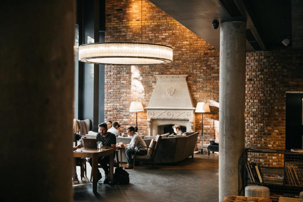 a group of people sitting at tables in a restaurant at The Hoxton, Shoreditch in London