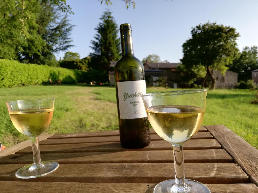zwei Gläser Weißwein neben einer Flasche Wein in der Unterkunft Casa Bellocchio in Castel Giorgio