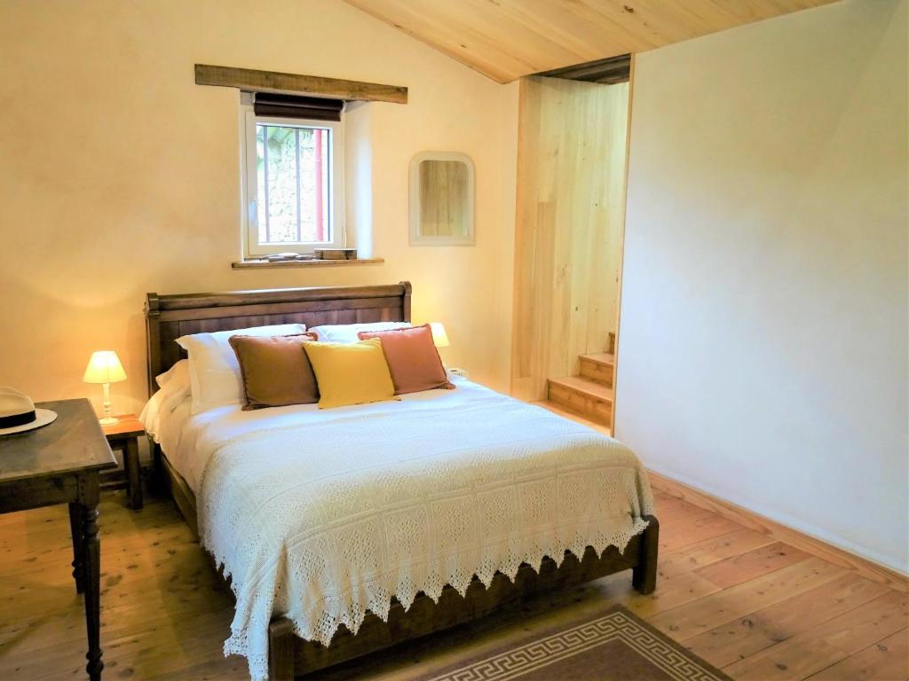 1 dormitorio con cama, mesa y ventana en Terre et Eau chambres d'hotes B&B La Flocellière en La Flocellière