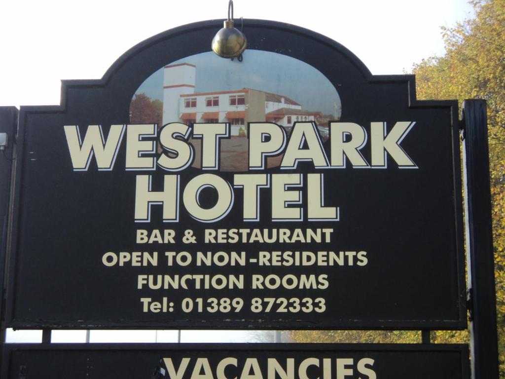 a sign for a west park hotel with a building at west park hotel chalets in Clydebank