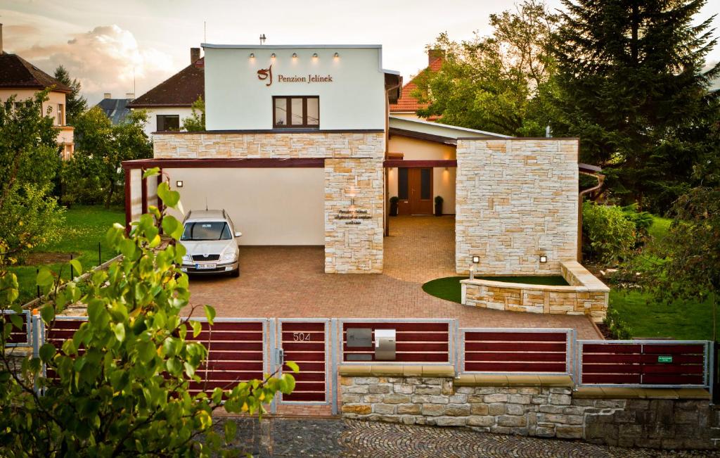 a house with a car parked in the driveway at Penzion Jelínek in Opočno