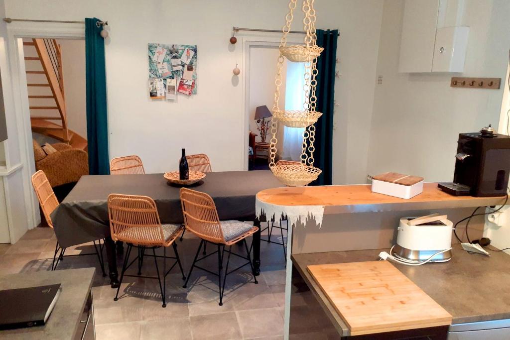 Il comprend une cuisine et un salon avec une table et des chaises. dans l'établissement Gîte "La Cachette Bourgueilloise", à Bourgueil