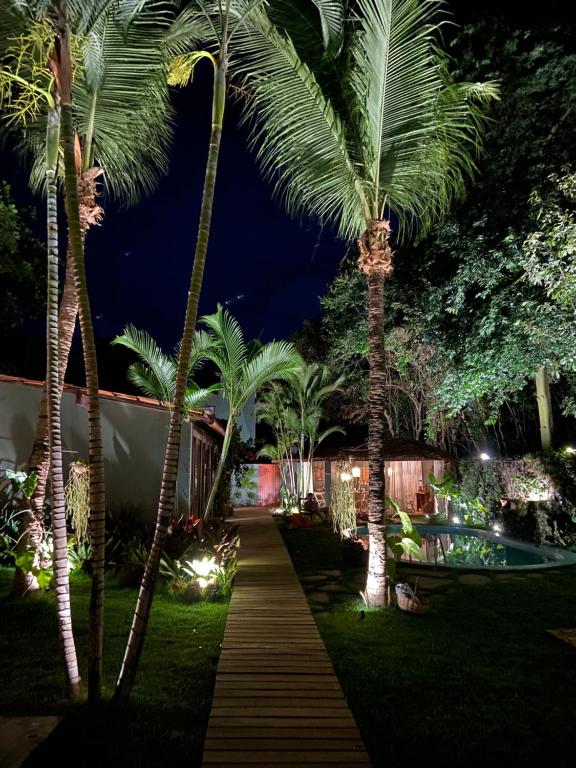 um jardim à noite com palmeiras e um caminho em Kûara Pipa em Pipa