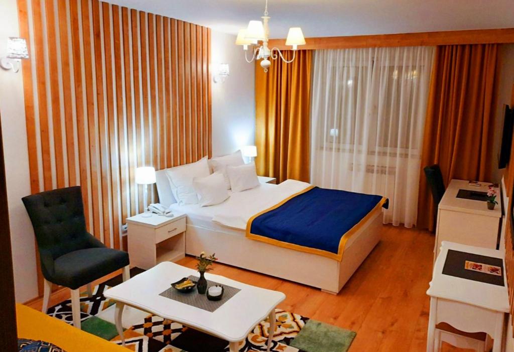 um quarto de hotel com uma cama e uma cadeira em Hotel JET SET Pale em Pale