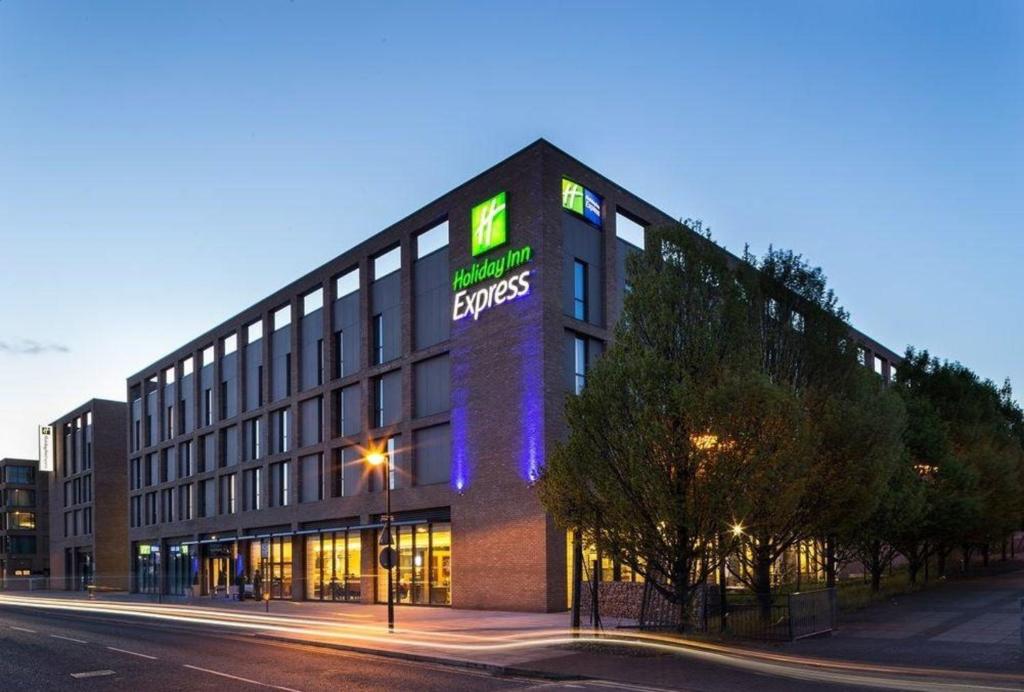a large building with a clock on the front of it at Holiday Inn Express London - ExCel, an IHG Hotel in London