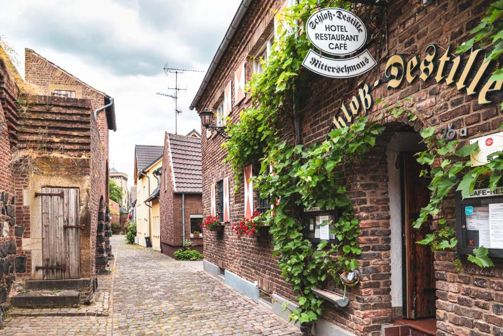 an alley with ivy on the side of a brick building at Schloß Destille in Dormagen