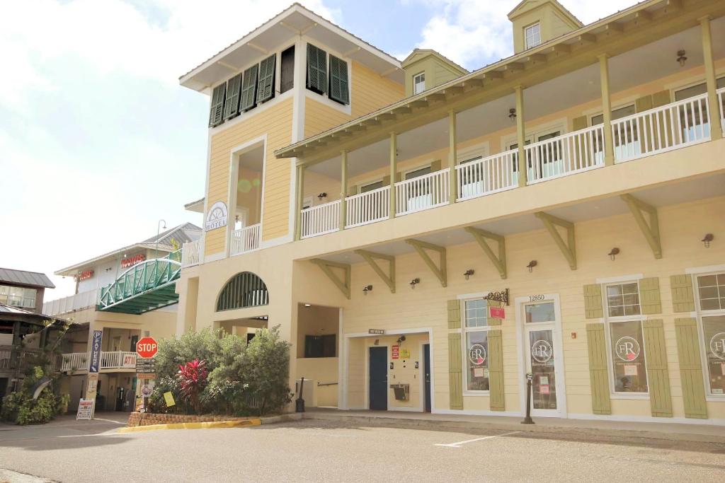 un gran edificio amarillo con una señal de stop delante de él en John's Pass Hotel - Fully Remote Check In en St Pete Beach