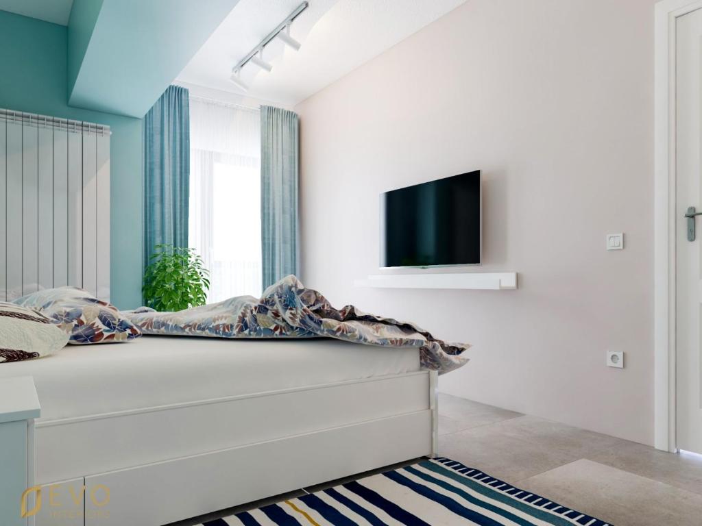 a bedroom with a bed and a tv on a wall at Mamaia Beach LuxyMar 1 Apartment in Mamaia