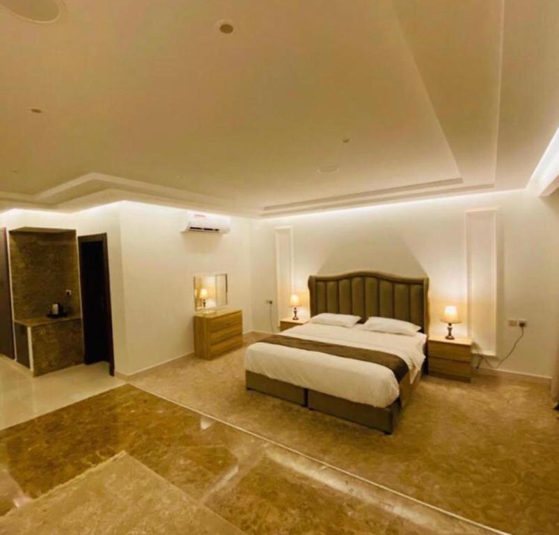 1 dormitorio grande con 1 cama y 2 mesitas de noche en راحتي هوم, en Al Rass