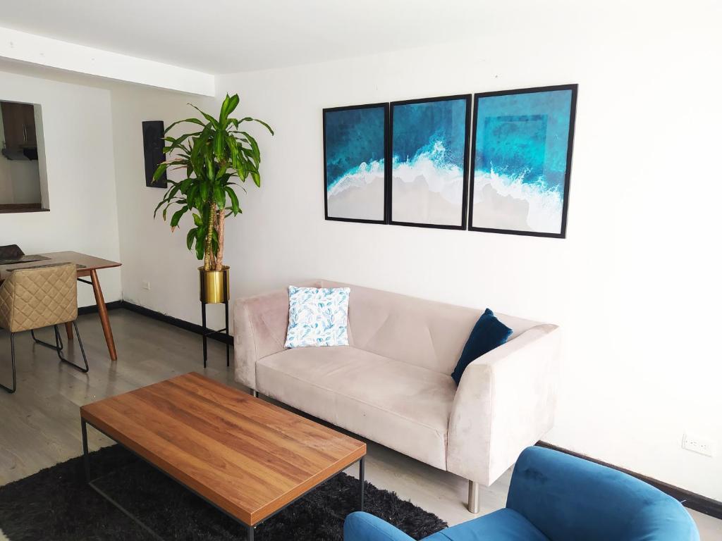 ein Wohnzimmer mit einem Sofa und einem Tisch in der Unterkunft 3 Apartamento completo Cedritos Minimalista in Bogotá