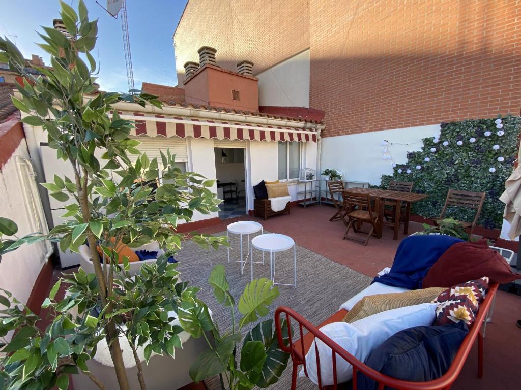 um pátio com uma mesa e cadeiras numa varanda em INSIDEHOME Apartments - Ático de Calle Mayor em Palencia