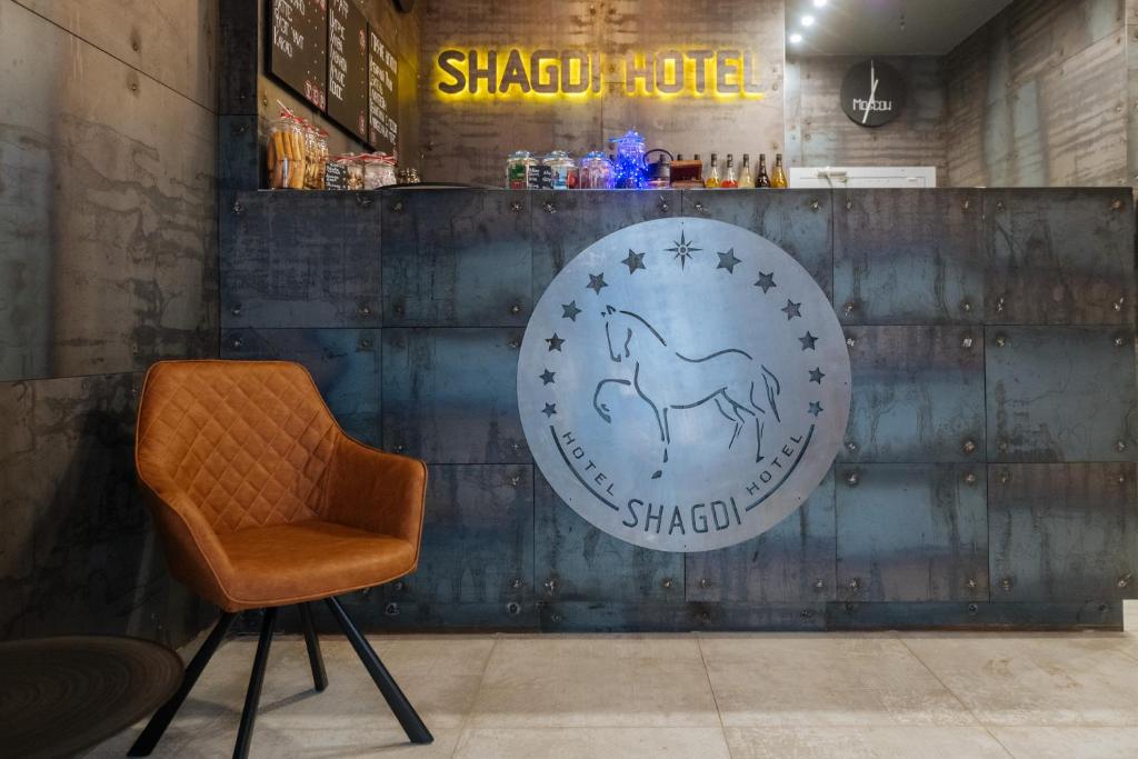 Shagdi Hotel في موسكو: كرسي في غرفة مع علامة على الحائط
