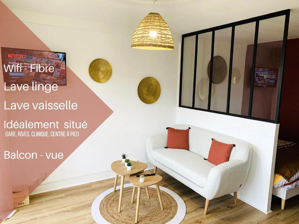 a living room with a white couch and a table at Studio ScandiChic tout équipé centre-gare-rives-clinique à pied in Caen