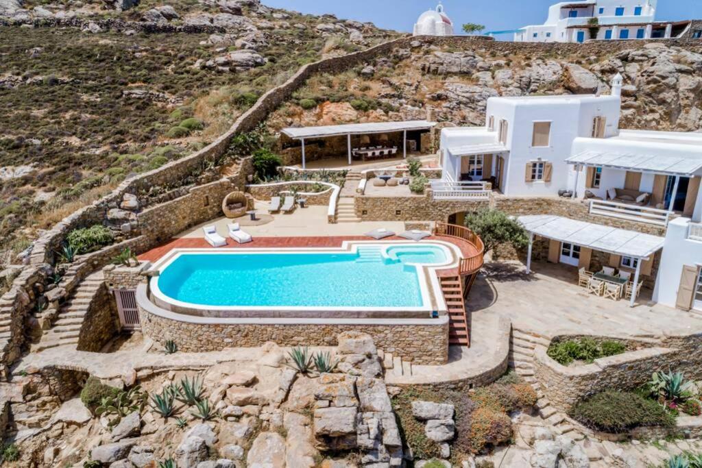 a villa with a swimming pool on a hill at Amazing Deep Blue Villa Mykonos in Mikonos