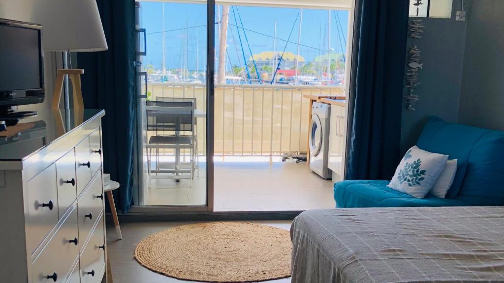 圣弗朗索瓦LES MARINES KAZATIBO的一间带床的卧室，可欣赏阳台景色