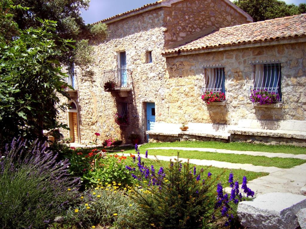 a stone building with flowers in front of it at Casa Sadde in Padru