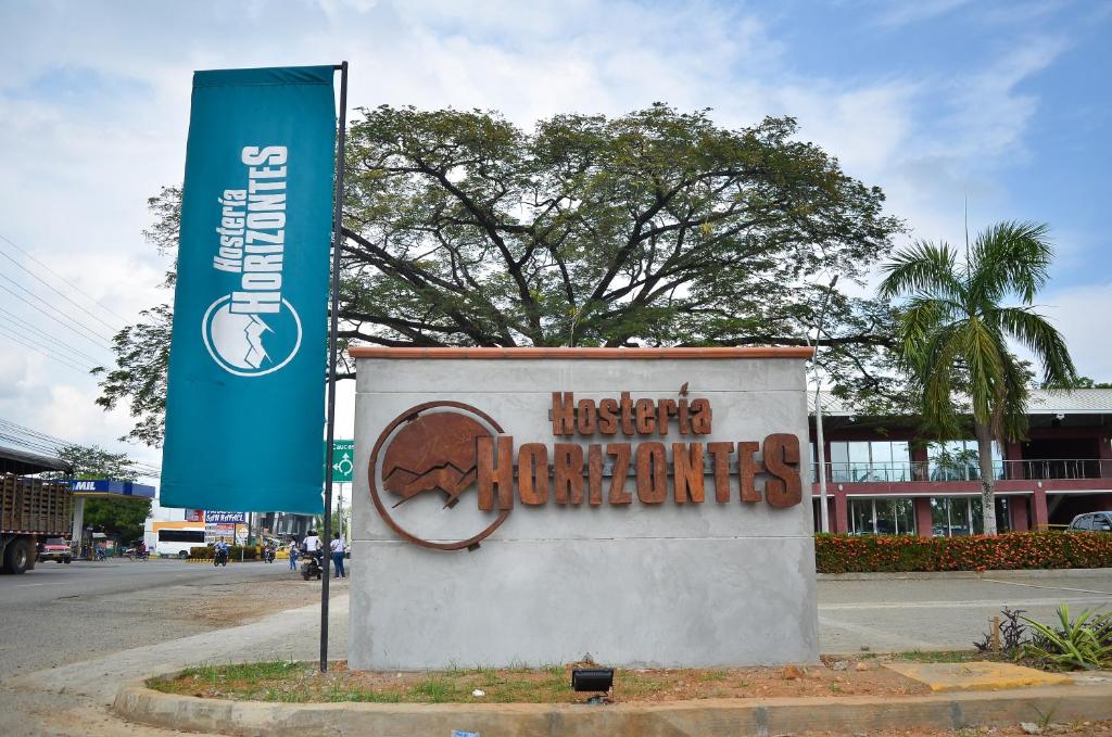 a sign on the side of a building with a banner at Hostería Horizontes in Caucasia