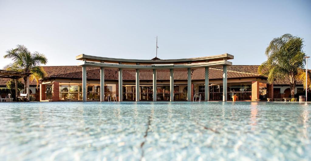 um edifício com uma piscina de água em frente em Tenondé Park Hotel em São Miguel das Missões