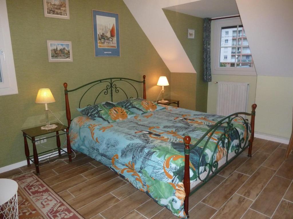a bedroom with a bed with a colorful comforter at Résidence Honfleuraise in Honfleur
